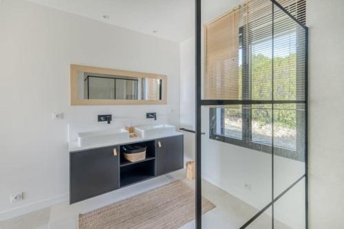 une salle de bain avec un lavabo et un miroir dans l'établissement Villa classée 4 étoiles , vue mer , piscine, clim, parking, à La Croix-Valmer