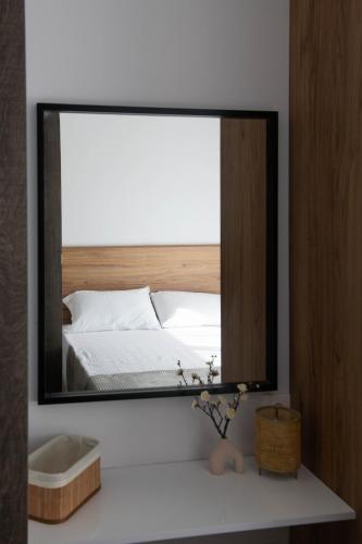 a mirror on a table with a bed in a bedroom at SKIA luxury living above the walls in Thessaloniki