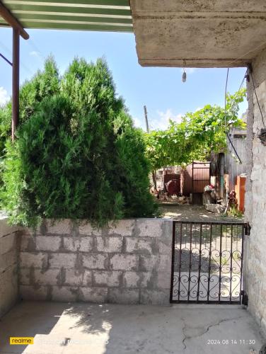 a gate in a brick wall with a bush at Armen bed and breakfast in Halidzor