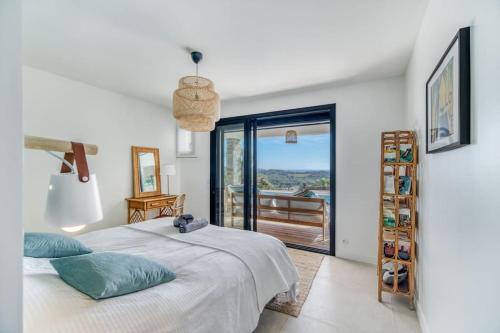 une chambre avec un lit et un balcon dans l'établissement Villa 4 étoiles, 250m2, piscine, parking, vue mer, à La Croix-Valmer
