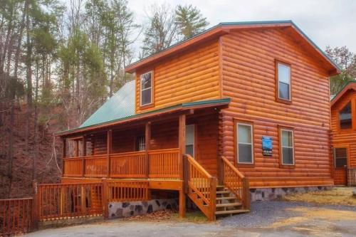 a large wooden cabin with a large deck at Papa Wolf's Cabin - POOL Community in Pigeon Forge