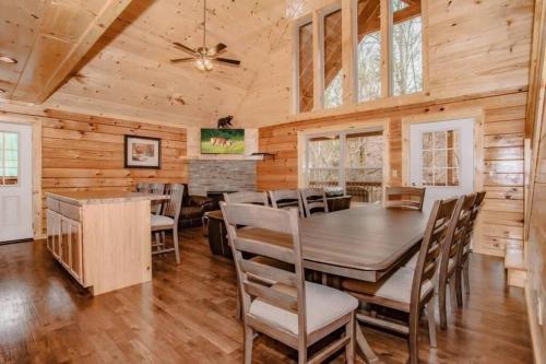 a dining room with a table and chairs at Papa Wolf's Cabin - POOL Community in Pigeon Forge