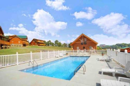 a swimming pool with chairs and a house at Papa Wolf's Cabin - POOL Community in Pigeon Forge
