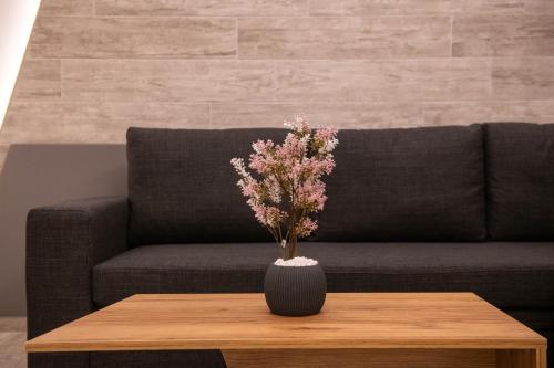 a vase on a coffee table in front of a couch at SKIA luxury living above the walls in Thessaloniki