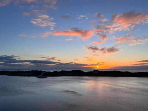 a sunset over a large body of water at Havre de paix à proximité de l'océan in Plonéour-Lanvern