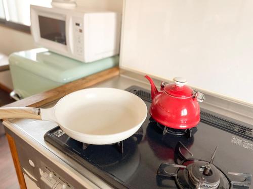 a white bowl on a stove with a red tea pot at Barber HARUNA in Akutsu