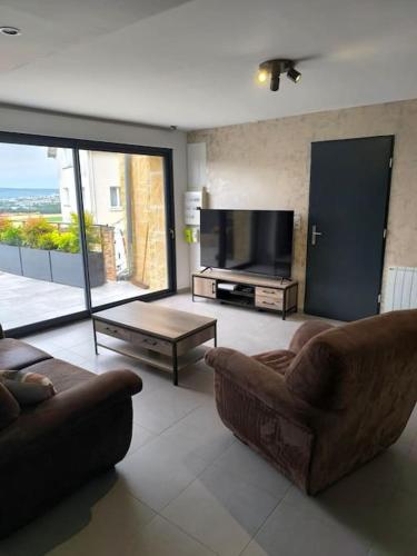 un salon avec deux canapés et une télévision dans l'établissement chez Julien, à Chavot-Courcourt