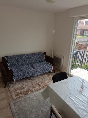 ein Wohnzimmer mit Sofa und Tisch in der Unterkunft Maison Charmante et Jardin Privé à Gagny - Proche Paris in Gagny