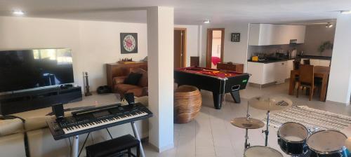 a living room with a piano and a room with a kitchen at Casa da Colina in Loulé
