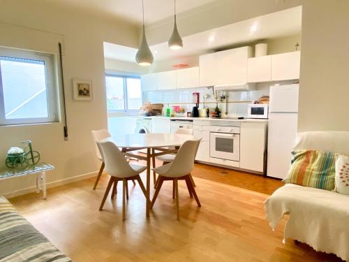 a kitchen and dining room with a table and chairs at Casa do Pátio in Figueira da Foz
