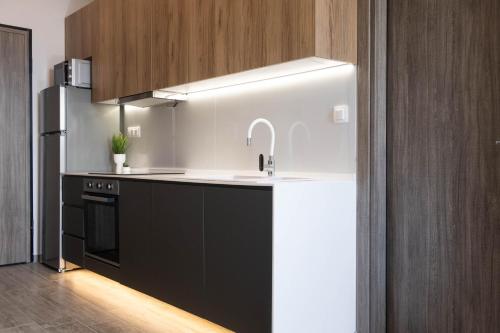 a kitchen with a sink and a refrigerator at SKIA luxury living above the walls in Thessaloniki