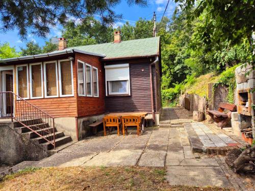 a small wooden house with a table and a porch at Riverside Forest Guesthouse in Lelʼa