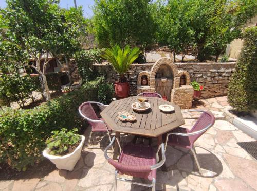 a wooden table and chairs in a garden at Villa Mitsi Sarande in Sarandë