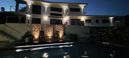 une maison avec une piscine en face de celle-ci la nuit dans l'établissement Luxueux appartement dans propriété contemporaine, jardin privatif, piscine, à La Roquette-sur-Siagne