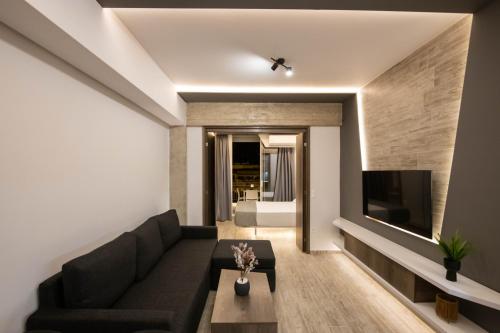 a living room with a couch and a tv at SKIA luxury living above the walls in Thessaloniki