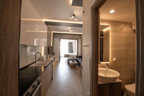 a bathroom with a sink and a toilet and a mirror at SKIA luxury living above the walls in Thessaloniki