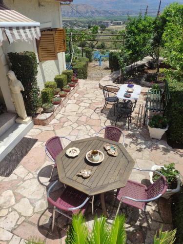 a patio with a table and chairs and a table and chairsktop at Villa Mitsi Sarande in Sarandë