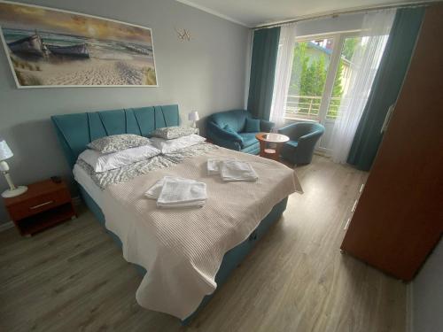 a bedroom with a bed with two towels on it at Altona in Władysławowo