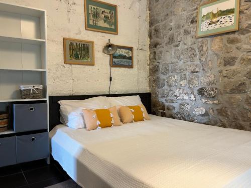 a bedroom with a bed with orange and white pillows at Artist's House on the Mountain in Zelenika