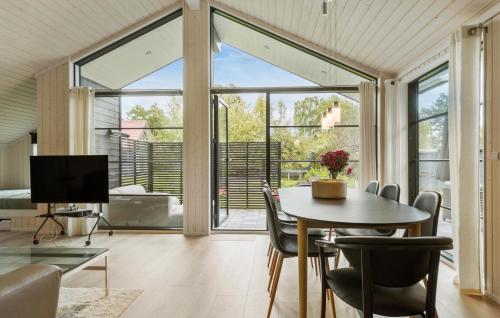 a living room with a table and chairs and a television at Amazing Home In Ebeltoft With Kitchen in Ebeltoft