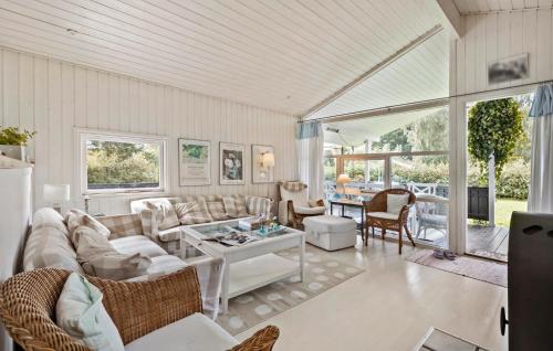 a living room with a couch and a table at Four-Bedroom Holiday Home In Hornbak in Hornbæk