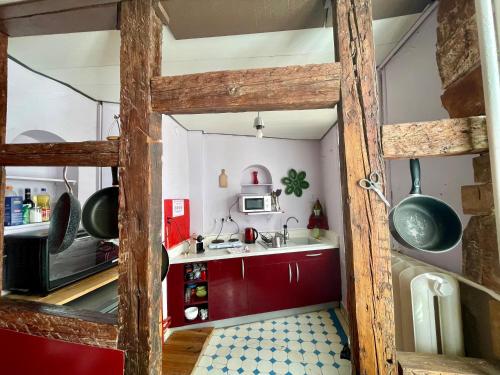 une petite cuisine avec des placards rouges et un four micro-ondes dans l'établissement Cathédrale spacieux appartement, à Strasbourg
