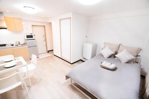 a living room with a bed and a kitchen at CG Charming Guesthouse in the Heart of Okubo 丶Steps to Metro and Convenient Travel! YoE4 in Tokyo
