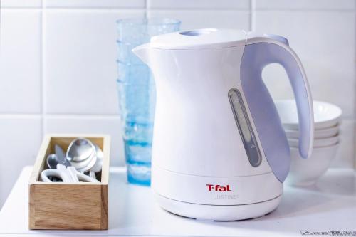 a tea kettle sitting next to a box of spoons at Charming Guesthouse in the Heart of Okubo 丶Steps to Metro and Convenient Travel! EoW4 in Tokyo