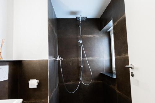 a bathroom with a shower with brown tiles at a Bäckesch 15 in Nettersheim