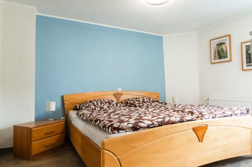 a bedroom with a bed and a blue wall at a Bäckesch 15 in Nettersheim