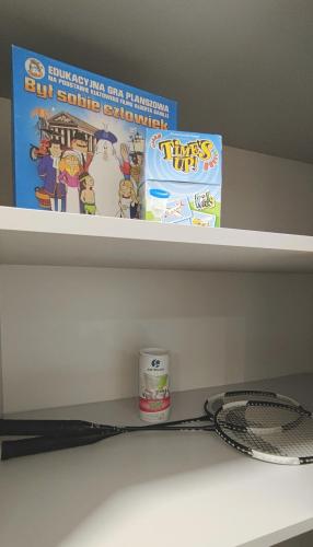 a shelf with a book and a box and a toothbrush at Tarnów Velo Apartament - Dom in Tarnów