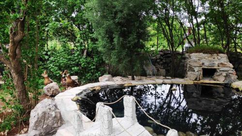 two deer standing on a bridge over a pond at Seosko domaćinstvo Peković in Danilovgrad