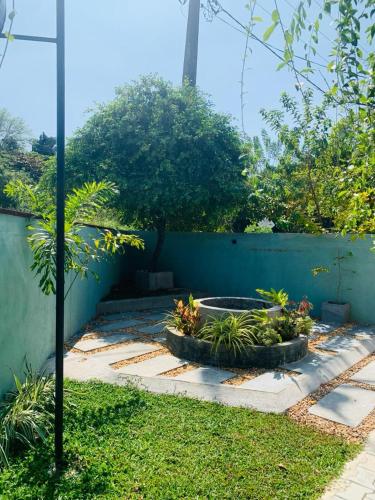 a garden with a retaining wall and a fountain at Coastal Dreams in Weligama
