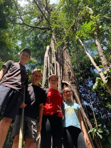 a group of people standing in front of a tree at Wisma Batu Mandi in Bukit Lawang
