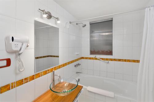 a bathroom with a tub and a sink and a mirror at Conde de Lemos Hotel in Puno