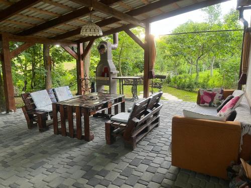 a patio with a wooden table and chairs at Hotel Окремий Будинок-Апартаменти in Rakoshyno
