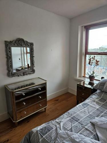 a bedroom with a dresser and a mirror on the wall at Spacious 3-Bedroom Apartment in Vibrant Dublin 8 in Dublin