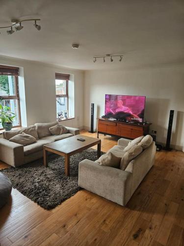 a living room with two couches and a flat screen tv at Spacious 3-Bedroom Apartment in Vibrant Dublin 8 in Dublin