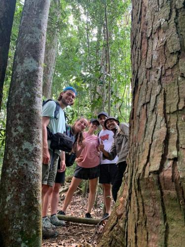 a group of people standing next to a tree at Wisma Batu Mandi in Bukit Lawang