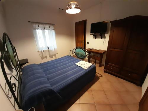 a bedroom with a blue bed and a television at Casale del Gufo in Chiaravalle
