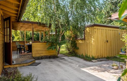 a backyard with a wooden fence and a table at 3 Bedroom Gorgeous Home In Jægerspris in Jægerspris