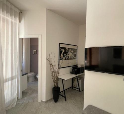 una stanza bianca con una scrivania e un bagno di SIEPELUNGA B&B a Bologna