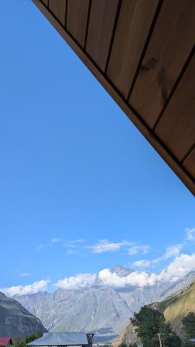 a view of the mountains and clouds in the sky at Rest point cottage Kazbegi in Stepantsminda
