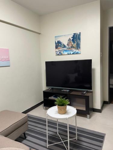 a living room with a large flat screen tv at Eves Urban Haven in Manila