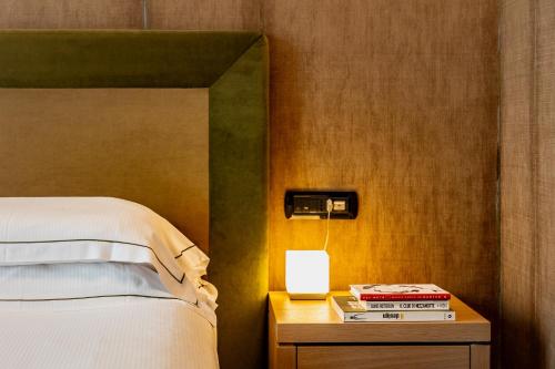 a bedroom with a bed and a table with a lamp at Phi Hotel Piajo in Nembro