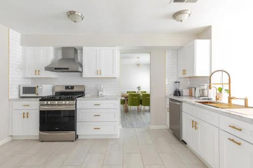 a kitchen with white cabinets and a stove top oven at P&Ds Harmony House 20 Mins to Airport & Downtown in Decatur