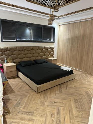 a bedroom with a large bed and a wooden floor at Villa avec piscine oujda CGI in Oujda