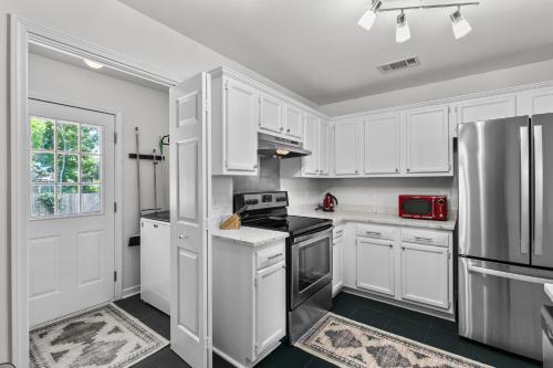 a kitchen with white cabinets and a stainless steel refrigerator at The Cozy Spot in Brandon