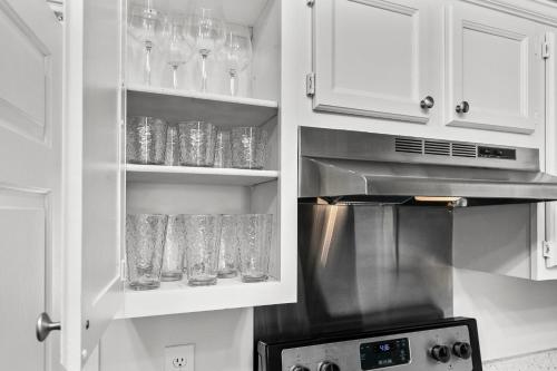 a kitchen with white cabinets with glasses on shelves at The Cozy Spot in Brandon