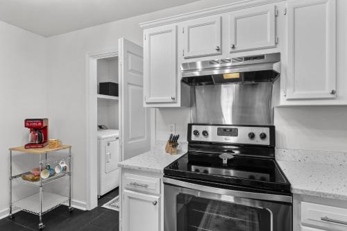 a kitchen with white cabinets and a stove top oven at The Cozy Spot in Brandon